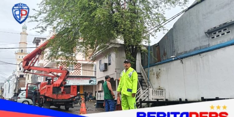 Bhabinkamtibmas Polsek KPN Dampingi Pemangkasan Pohon di Permukiman Warga